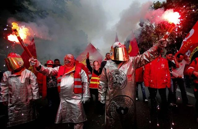 Labor union workers wearing masks protest during a demonstration in Paris, on October 9, 2012. The CGT, France's biggest trade union, has called for a national day of protest against government austerity, job cuts and plant closures. (Photo by Christophe Ena/Associated Press)