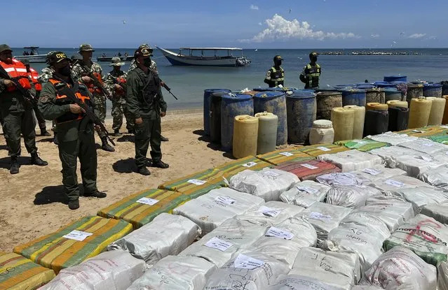 Sacks containing illegal drugs and plastic barrels containing fuel, seized by the armed forces of Venezuela are displayed at a beachside campsite in the village of Tiraya, Venezuela, Monday, September 5, 2022. The armed forces of Venezuela announced what they characterized as the largest marijuana bust of the last 10 years after they intercepted a boat off the country's Caribbean coast over the weekend. (Photo by Regina Garcia Cano/AP Photo)