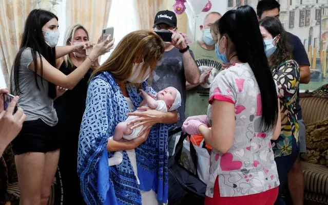 Participants of a ceremony surround Andrea Diez and Fernando Montero, Argentine citizens and parents of newborn Ignacio, during the couple's first meeting with their baby in the Hotel Venice owned by BioTexCom clinic in Kiev, Ukraine on June 10, 2020. The coronavirus disease (COVID-19) lockdown prevented Andrea and Fernando from collecting their baby born to a surrogate mother, after almost all air travel was shut down. (Photo by Gleb Garanich/Reuters)