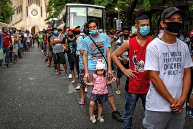 Filipinos out of work and stranded due to the coronavirus pandemic queue to receive meals before taking a free bus ride home to their province on May 29, 2020 in Paranaque, Metro Manila, Philippines. The Philippine government is set to ease the country's lockdown starting Monday, after more than two months of strict quarantine measures that has left millions of Filipinos jobless and hungry. The Philippines' Department of Health has so far reported 16,634 cases of the coronavirus in the country, with at least 942 recorded fatalities. (Photo by Ezra Acayan/Getty Images)