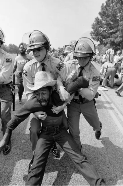 North Carolina State Police exert a tight grip on protestor on the road to the Warren County Landfill in Afton, North Carolina, Friday, September 17, 1982. Several protestors were arrested when they tried to block PCB laden trucks. (Photo by Steve Helber/AP Photo)