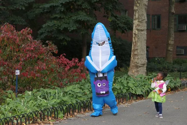 People dressed as Baby Shark and Tinker Bell walk in Stuy Town on Halloween in Manhattan, New York City, U.S., October 31, 2022. (Photo by Andrew Kelly/Reuters)
