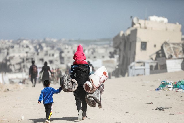 Palestinians make their way to flee their homes, after the Israel army issued evacuation orders for a number of neighborhoods, following heavy Israeli strikes, in Beit Lahiya in the northern Gaza Strip on March 18, 2025. (Photo by Abd Elhkeem Khaled/Reuters)