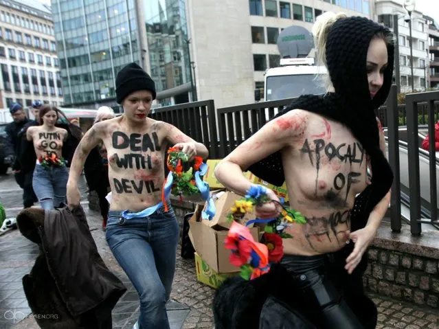 An activist of Ukraine's feminist movement Femen is taken away by the police as she demonstrates by the EU Council building where the EU-Russia summit is taking on December 21, 2012 in Brussels, Belgium. (Photo by Georges Gobet/AFP Photo)