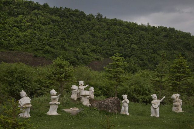 In this June 16, 2014 photo, statues of animals playing musical instruments stand along the roadside south of Samsu, North Korea in Ryanggang province. (Photo by David Guttenfelder/AP Photo)