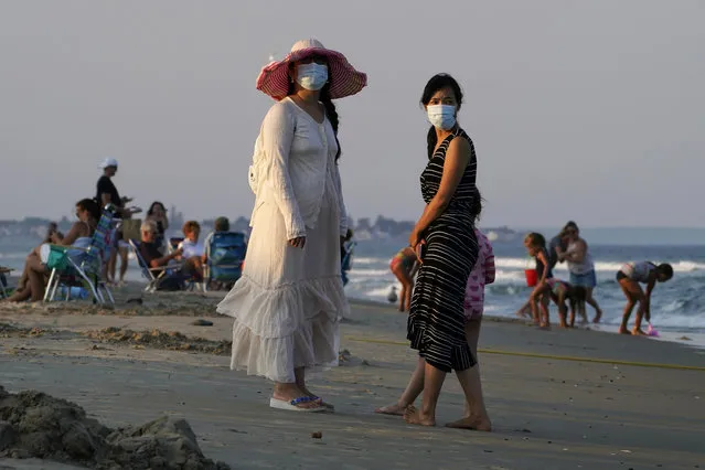 Women wear masks to help prevent the spread of coronavirus at the end of a beach day, Tuesday, August 11, 2020, in Ogunquit, Maine. (Photo by Robert F. Bukaty/AP Photo)