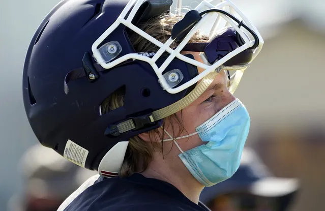Thrall High School football player Hayden Stefek wears a face mask as he goes through a practice, Thursday, August 13, 2020, in Thrall, Texas. Coronavirus testing in Texas has dropped significantly, mirroring nationwide trends, just as schools reopen and football teams charge ahead with plans to play. (Photo by Eric Gay/AP Photo)