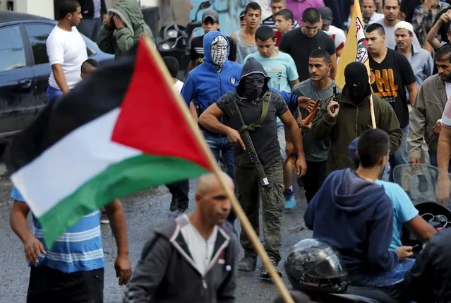 Palestinian gunmen carry weapons as they take part in the funeral of 22-year-old Palestinian Ahmad Qali, who was shot by Israeli troops during late-night clashes, in the Palestinian refugee camp of Shuafat near Jerusalem October 10, 2015. (Photo by Ammar Awad/Reuters)