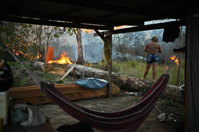 Idelia Lima Lisboa, wife of a farmer who set fire to rainforest around his property looks on as the fire approaches their house in an area of Amazon rainforest, south of Novo Progresso in Para state, Brazil, on August 15, 2020. (Photo by Carl De Souza/AFP Photo)