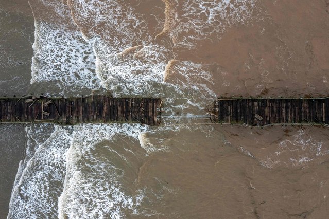 This aerial view shows the Capitola Pier, built in 1857, damaged after recent storms in Capitola, California, on January 15, 2023. Soggy Californians on Sunday wearily endured their ninth successive storm in a three-week period that has brought destructive flooding, heavy snowfalls and at least 19 deaths, and forecasters said more of the same loomed for another day. (Photo by David McNew/AFP Photo)