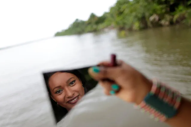 A member of the “Bloco Real Folia” group uses a piece of mirror during Carnival of the Waters, where costumed and colorful boats navigate the river Jaituba, around the islands near the city of Cameta, Brazil on February 8, 2018. (Photo by Ueslei Marcelino/Reuters)