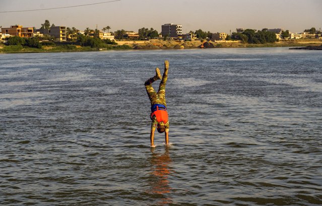 A member of the Rapid Response Forces of the Ministry of Interior jumps down into the Tigris River in Baghdad, Iraq on July 12, 2025, during the “Trust Jump” training exercise on the 14th Ramadan Bridge. The drill was carried out by both officers and personnel following the completion of their preparatory training. (Photo by Ali Abdul Wahid/Middle East Images via AFP Photo)