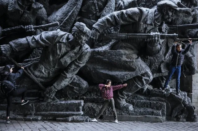 Children play next to the bronze monument at the World War II museum complex in Kiev, Ukraine, 28 October 2015. Ukrainians mark 71th anniversary of the liberation of Ukraine from the Nazi occupation during WWII. (Photo by Roman Pilipey/EPA)