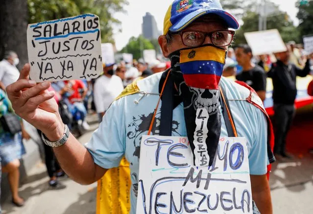 A demonstrator holds a sign that reads “Fair Salaries Now” during a march to demand better salaries, as the government of President Nicolas Maduro faces renewed challenges in its attempt to fight inflation, in Caracas, Venezuela January 23, 2023. (Photo by Leonardo Fernandez Viloria/Reuters)
