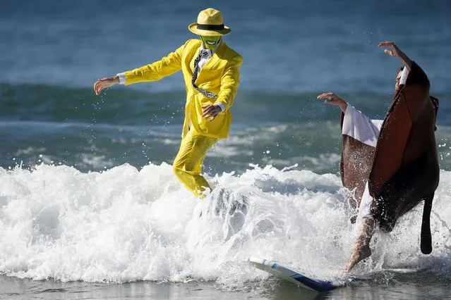 David Nicholson, 21, (L) surfs as "The Mask" during the ZJ Boarding House Haunted Heats Halloween Surf Contest in Santa Monica, California, United States, October 31, 2015. (Photo by Lucy Nicholson/Reuters)