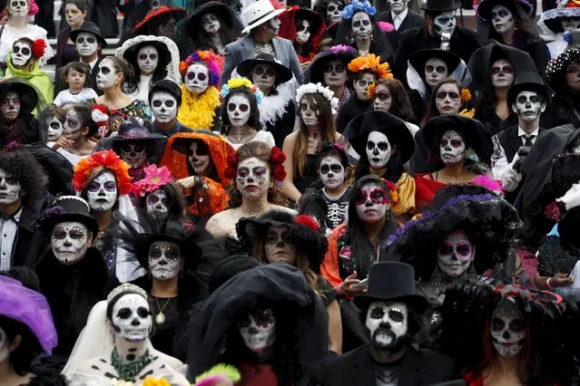 People with their faces painted to look like the popular Mexican figure called "Catrina" take part in the annual Catrina Fest in Mexico City November 1, 2015. According to participants, about 310 women gathered at the Catrina Fest, where women dressed to look like "Catrina", a character also known as "The Elegant Death", created by Guadalupe Posada in the early 1900s. Mexicans celebrate the annual Day of the Dead on November 1 and 2. (Photo by Carlos Jasso/Reuters)