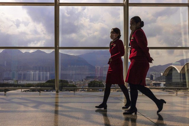 Cathay Pacific Airways employees walk through the departures hall of Hong Kong International Airport in Hong Kong, on Wednesday, March. 8, 2023. (Photo by Louise Delmotte/AP Photo)