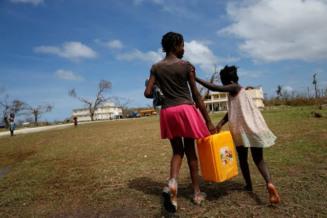 Children carry a plastic container filled with water in a damaged orphanage after Hurricane Matthew passes Jeremie, Haiti, October 11, 2016. (Photo by Carlos Garcia Rawlins/Reuters)