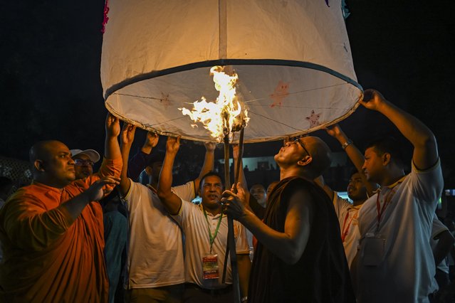 Buddhist devotees release a paper lantern to celebrate the religious festival Probarona Purnima in Dhaka, Bangladesh, on October 6, 2025. Probarona Purnima is one of the biggest festivals of the Buddhist community, and this festival is celebrated during the full moon. (Photo by Zabed Hasnain Chowdhury/NurPhoto/Rex Features/Shutterstock)