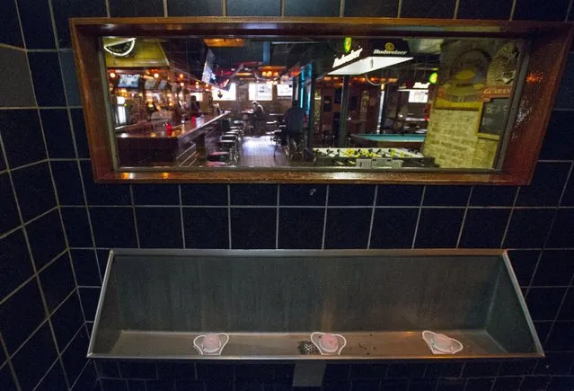 A one-way mirror is seen above the urinal at Streeter's Tavern in Chicago, Illinois, United States, September 30, 2015. Customers using the the bathroom can see into the main area of the bar, but cannot be seen by the people at the bar. (Photo by Jim Young/Reuters)