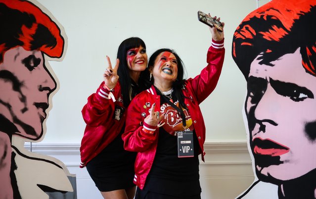 David Bowie super-fans Sonia Wike (L) and Ersula Martell pose for a selfie with portraits of David Bowie by artist Mark Wardol at a David Bowie World Fan Convention, in Liverpool, Britain, 26 July 2024. Liverpool is hosting the third David Bowie World Fan Convention, known as “BowieCon”, which celebrates the iconic British musician through film screenings, memorabilia and meet-and-greets with creatives and former collaborators. (Photo by Adam Vaughan/EPA/EFE)