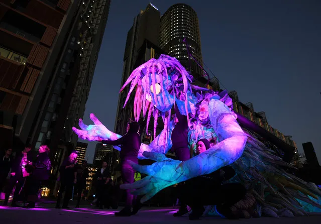 A team of performers move a six- meter- tall creature illuminated with lights during a Vivid Sydney media preview at Barangaroo in Sydney on May 23, 2018. “Vivid” is a major outdoor cultural event featuring light installations and projections with the annual event this year running from May 25 to June 16, 2018. (Photo by Saeed Khan/AFP Photo)