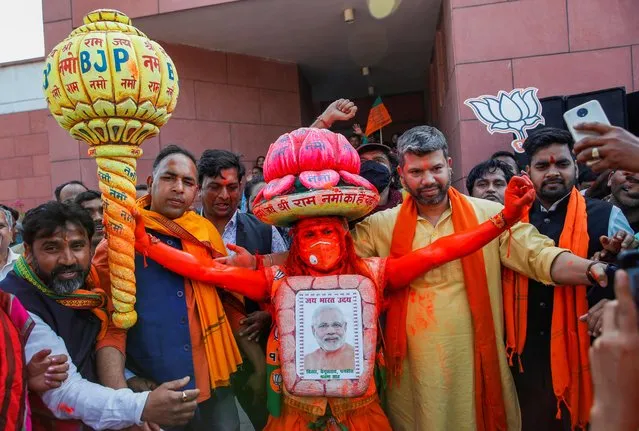 A supporter of India's ruling party Bharatiya Janata Party (BJP) dressed as Hanuman, the Hindu monkey god, dances with others as they celebrate after learning the initial poll results at the party headquarter in New Delhi, India, March 10, 2022. (Photo by Adnan Abidi/Reuters)