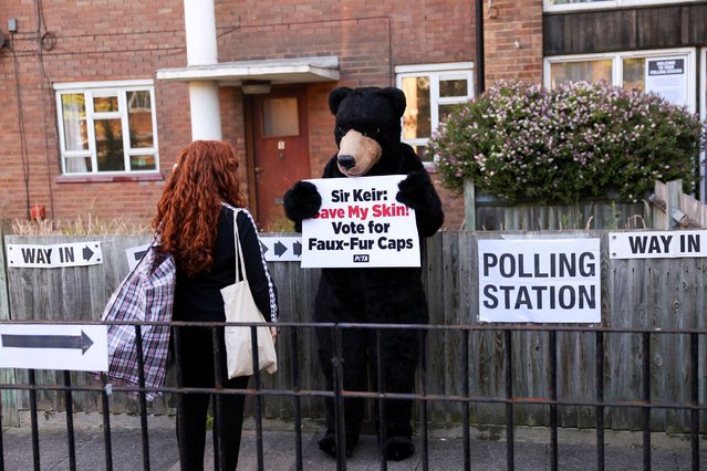 A PETA activist dressed as a bear holds a sign outside a polling station during the general election in London, Britain, on July 4, 2024. (Photo by Claudia Greco/Reuters)