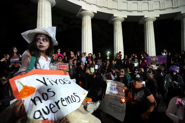 A girl with her face painted to look like popular Mexican figure “Catrina” holds a sign in a march against femicides during the Day of the Dead at Hemiciclo a Juarez in Mexico City, Mexico, November 1, 2016. (Photo by Edgard Garrido/Reuters)