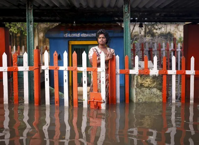 A woman stands at a fenced gate of a partially submerged temple in Chennai, India, December 4, 2015. (Photo by Anindito Mukherjee/Reuters)