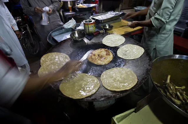 A Pakistani vendor fried bread locally called “Paratha” preparing for “sehri”, the pre-dawn meal for Muslims observing Ramadan, in Rawalpindi, Pakistan, Saturday, June 2, 2018. Muslims across the world are observing the holy fasting month of Ramadan, where they refrain from eating, drinking and smoking from dawn to dusk. (Photo by B.K. Bangash/AP Photo)