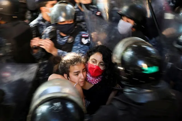 Students from American Univeristy of Beirut stand among policemen as they protest over tuition fees in Beirut, Lebanon on December 29, 2020. (Photo by Mohamed Azakir/Reuters)