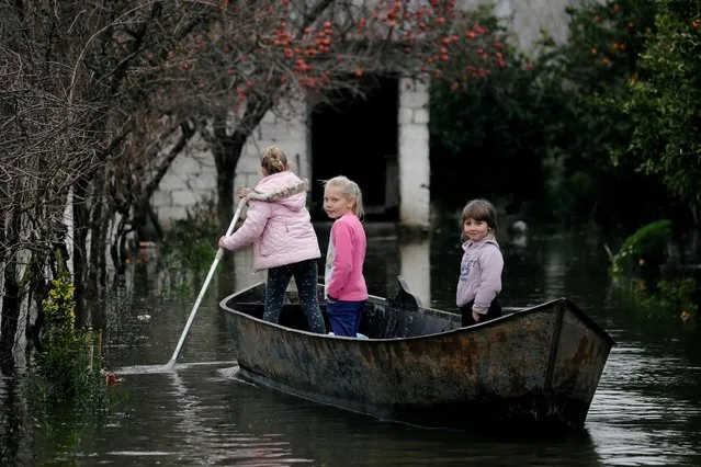 Children use a boat at a flooded area in Obot village, near Shkodra, Albania on January 12, 2021. (Photo by Florion Goga/Reuters)