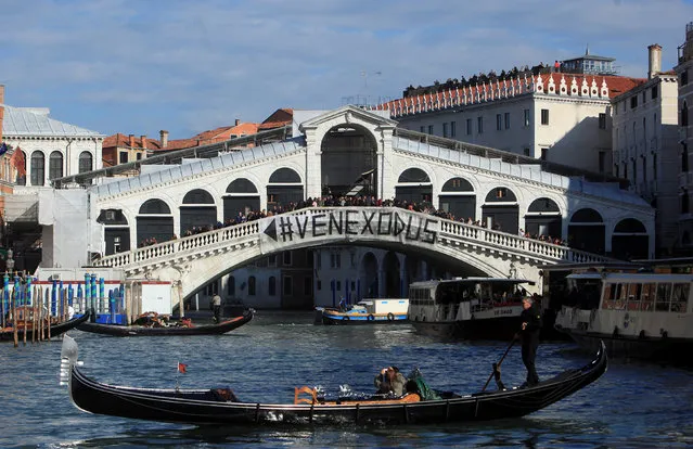 A banner reading “Venice Exodus” is displayed on the Rialto Bridge in a protest that calls for the authorities to think of the local community and not just about tourists, in Venice, Italy, November 12, 2016. (Photo by Manuel Silvestri/Reuters)