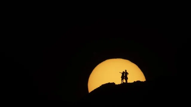 Two hikers are silhouetted against the setting sun at Papago Park in Phoenix, Sunday, February 21, 2021. (Photo by Jae C. Hong/AP Photo)