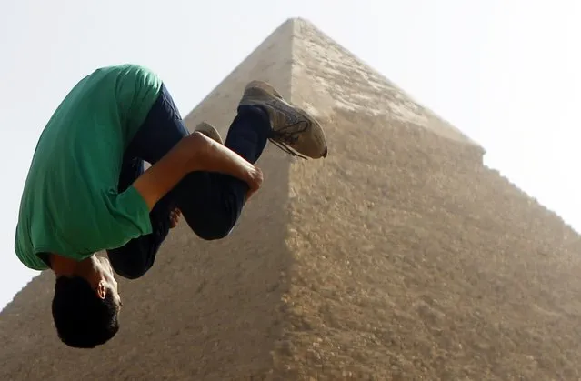 Faisel,16, a member of Egyptian parkour group “EGY PK”, practices a jump in front of the Pyramid of Khufu, the largest of the Great Pyramids of Giza, on the outskirts of Cairo on December 9, 2014. (Photo by Amr Abdallah Dalsh/Reuters)