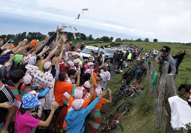 Spectators attempt to catch rattle clackers during stage 2 of the Tour de France cycling race over 209 kilometers (130 miles) with start in Vitoria Gasteiz and finish in San Sebastian, Spain on July 2, 2023. (Photo by Vincent West/Reuters)