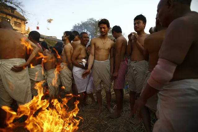 Devotees warm themselves by a fire before taking a dip in the Hanumante River, on the final day of the month-long Swasthani festival, at Bhaktapur near Kathmandu, February 3, 2015. (Photo by Navesh Chitrakar/Reuters)