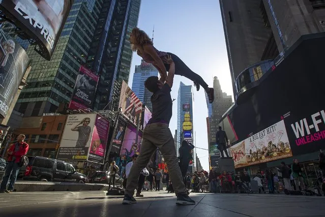 A couple practices dance moves in Times Square in the Manhattan borough of New York October 20, 2015. (Photo by Carlo Allegri/Reuters)