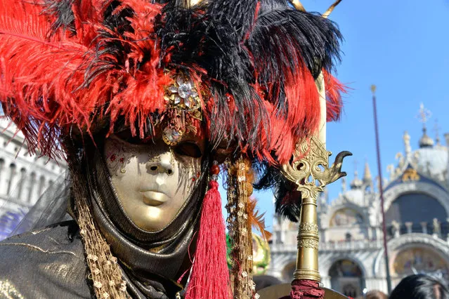 A dressed-up carnival reveller poses on the dock at San Marco Square during the second day of Carnival in San Marco Square, in Venice, Italy, February 8, 2015. (Photo by Andrea Merola/EPA)