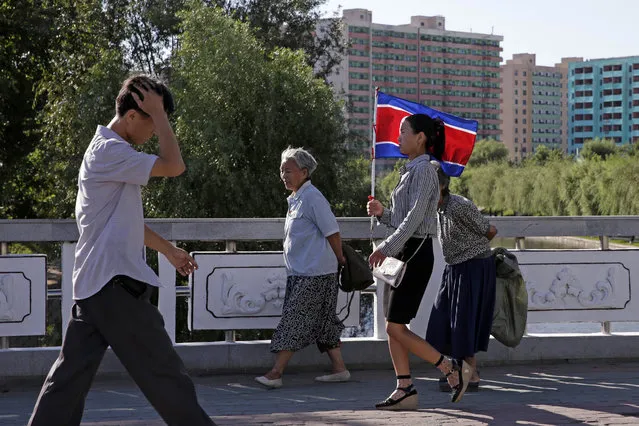 A woman carries a North Korean flag on the streets of Pyongyang, North Korea, Friday, September 7, 2018. (Photo by Kin Cheung/AP Photo)