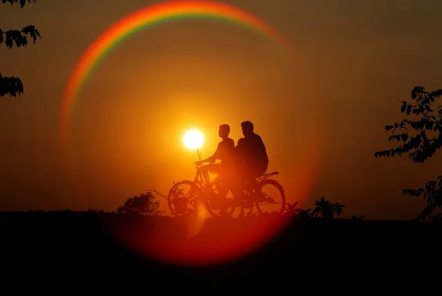Boys are silhouetted against the setting sun as they ride bicycles on the outskirts of Agartala, India, November 21, 2016. (Photo by Jayanta Dey/Reuters)