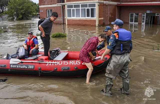 In this photo released by Russian Emergency Ministry Press Service on Sunday, August 13, 2023, Emergency service workers give assistance in a flooded village in Primorye region, Russia's Far East after heavy downpours flooded villages in the region in the aftermath of Typhoon Khanun. Russian emergency officials say over 2,000 people have been evacuated from flooded areas of the Primorye region in the country's Far East. (Photo by Russian Emergency Ministry Press Service via AP Photo)