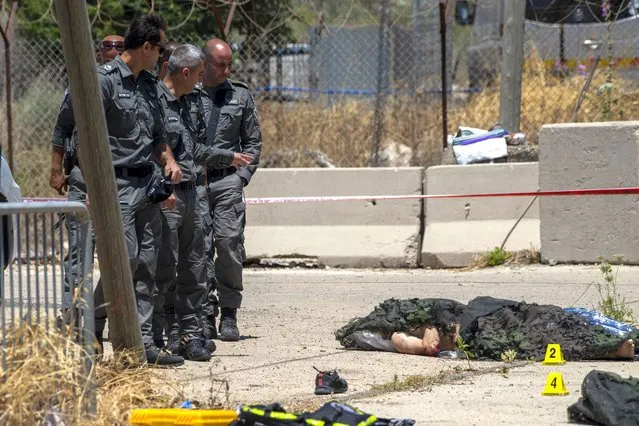 Israeli forces inspect the scene of a shooting attack where bodies of two Palestinian gunmen, killed by Israeli border police, lie on the ground in front of the military base of Salem near the West Bank town of Jenin, Friday, May. 7, 2021. Israeli troops shot and killed the two men and wounded a third after they opened fire on a border police base in the occupied West Bank. It was the latest in a series of violent confrontations amid soaring tensions in Jerusalem. (Photo by Gil Eliyahu/AP Photo)