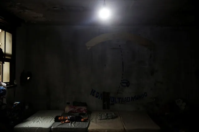 A child, relative of a member of the roofless movement who lives together with members of lesbian, gay, bisexual and transgender (LGBT) community, that have been invited to live in a building that the movement has occupied, sleeps, in downtown Sao Paulo, Brazil, November 28, 2016. (Photo by Nacho Doce/Reuters)