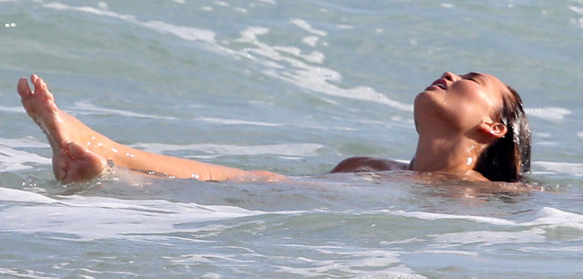 Supermodel Chrissy Teigen and singer husband John Legend are seen indulging in some PDA during a photo shoot with photographer Bruce Weber in Miami, FL., on March 12, 2015. After the couple was done posing together, Chrissy was seen dropping her robe and going completely nude into the ocean and frolicking in the waves before the photo shoot wrapped.  Pictured here: Chrissy Teigan. (Photo by Bruce Weber/INFphoto.com)