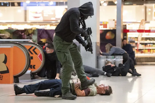 In this November 20, 2018 photo a man acting as a terrorist shoots a mock victim during an anti-terror exercise at the Cologne-Bonn-airport in Cologne, western Germany. About 1 000 police and rescue staff trained how to react on a terror attack in the so far biggest exercise on a German airport. (Photo by Marius Becker/DPA via AP Photo)