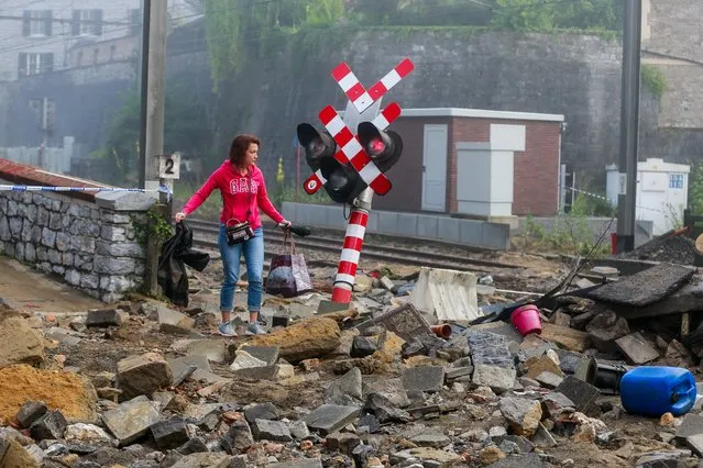 A woman searches for her clothes in the rubble after flooding due to heavy rains on 24 July, in Dinant, Belgium, 25 July 2021. Heavy rains caused widespread damage and flooding in parts of Belgium and across central Europe in the night of 14/15 July. Dozens have died and many remain unaccounted for. On July 24, more rain fell over southern Belgium. (Photo by Stephanie Lecocq/EPA/EFE)