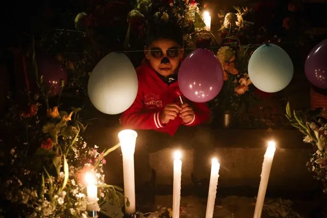 A kid takes part of Day of the Dead celebrations at San Andres Mixquic pantheon in Mexico City, on November 2, 2023. (Photo by Rodrigo Oropeza/AFP Photo)