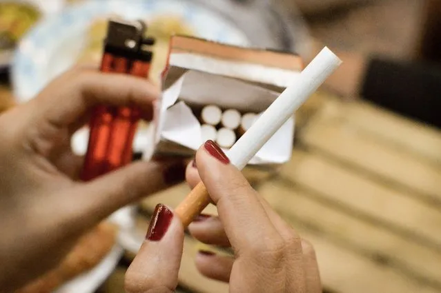 Close up of a woman's hands picking up cigarette from a box of cigarettes. (Photo by Irina Marwan/Getty Images)